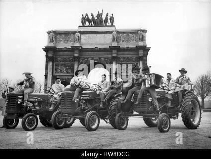 Mar 18, 1959 - Musicisti provenienti da Texas presente trattori; in occasione del francese Fiera Agricola che si aprono a Parigi domani, una band di musicisti provenienti da Texas presentati i trattori nelle strade di Parigi questo pomeriggio. La foto mostra i musicisti sui trattori fotografato di fronte all'arco di rotazione della giostra. (Credito Immagine: © Keystone Press Agency/Keystone USA via ZUMAPRESS.com) Foto Stock