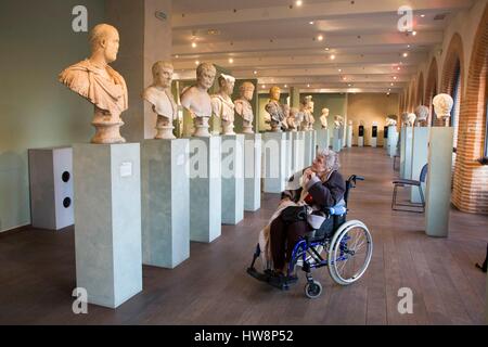 Francia, Haute Garonne, Toulouse, museo Saint Raymond, old Lady in una sedia a rotelle di fronte i busti di imperatori romani Foto Stock