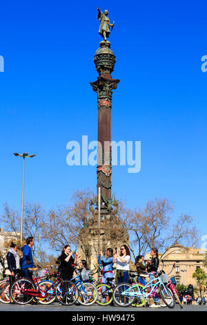 I turisti sulle biciclette stop per selfies presso il Mirador de Colom, Placa del Portal de La Pau,Port Vell, Maritine trimestre, Barcellona, Catalunya, Spagna Foto Stock