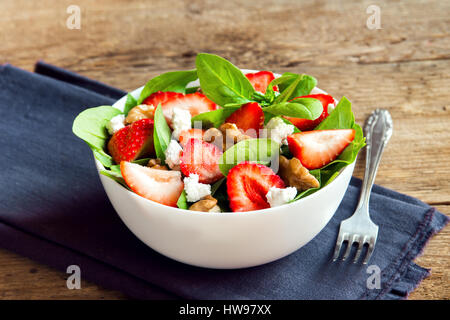 Fragole e insalata di spinaci con formaggio feta e noci, heathy organico la dieta vegetariana cibo insalata. Foto Stock