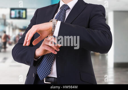 Imprenditore controllo tempo sul suo orologio da polso. Foto Stock