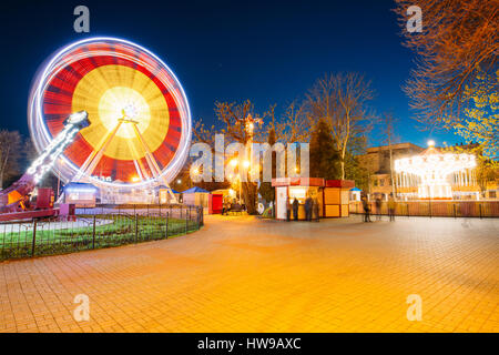 Rotante in moto naturale effetto di attrazione illuminato Ruota Panoramica sulla serata estiva in città parco divertimenti. Foto Stock