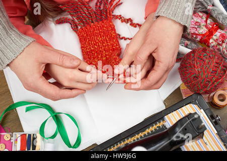 Madre figlia di insegnamento ragazza maglia, vista dall'alto, la cucitura accessori top view, sarta lavoro, molti oggetto per lavoro di ricamo a mano e artigianato Foto Stock