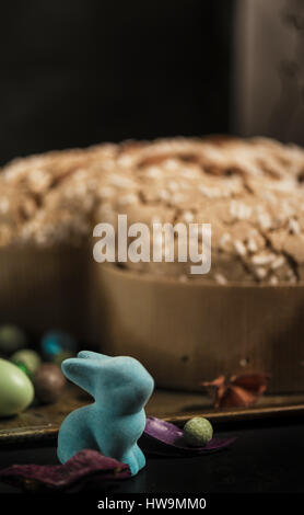Coniglietto di Pasqua, le uova e la torta su un buio cassetto arrugginito Foto Stock