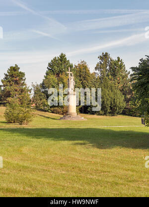 Statua barocca della Vergine Maria Azienda Croce nell autunno del giardino del palazzo Festetics a Keszthely, Ungheria. Foto Stock