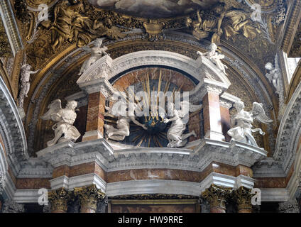 Angeli tenendo un globo con raggi dorati, e iniziali IMAS per i nomi di Gesù e Maria, altare maggiore nella chiesa Gesu e Maria a Roma Foto Stock