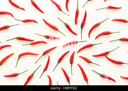 Un sacco di red hot chili peppers su uno sfondo bianco. un concetto di spezie calde per cibo. flat laici. Concetto red cibo, molti peperoni rossi come sfondo. Foto Stock