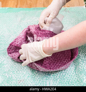 Laboratorio di fabbricazione di feltro per beret in umido processo di infeltrimento - hatter rimuove il cappello formato dal feltro umido il cofano Foto Stock