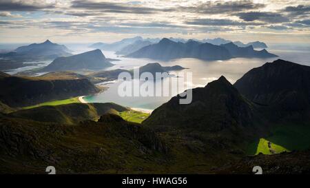 Norvegia, Nordland, isole Lofoten, isola Vestvagoy, la luce solare che cade su di Haukland, Vik e spiagge Utakleiv visto dalla vetta del Himmeltinden (962m Foto Stock