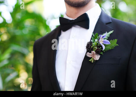 Dolce boutonniere per lo sposo con rose, crisantemo e perle Foto Stock