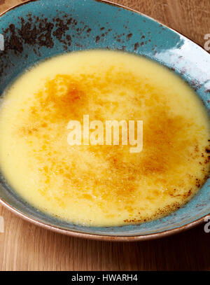 Ciotola di crema brule sul tavolo di legno Foto Stock