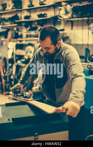 Sci e sintonizzazione reapair. Inverno shop lavoratore che fa la riparazione di base. Noleggio servizio officina Foto Stock