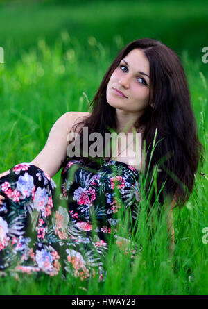 Molto bello e attraente,bella,carino,awesome,splendida,piuttosto,eccellente,perfetta ragazza seduta nell'erba verde.bella ragazza ha picnic nel parco.Attr Foto Stock