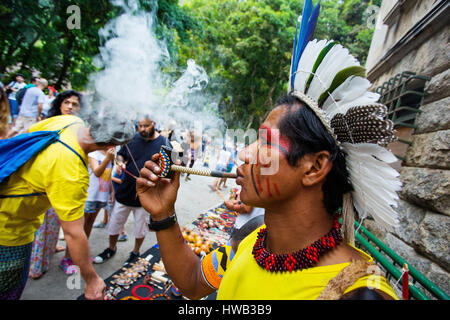 Brasiliano tradizionale indiano con faccia dipinta fumare la pipa al Parque Laje nel comemoration dell'indiano del giorno, Rio de Janeiro, Brasile Foto Stock