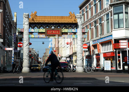 Un uomo di cicli passato il cancello di Chinatown all'Aia, Paesi Bassi, 16 marzo 2017. La destra partito liberale degli operatori storici di Primo Ministro Rutte è venuto fuori di elezioni parlamentari come la forza più potente. Destra populista Geert Wilders fissato sigificantly meno voti di erano attese con il suo Freedom Party (PVV). Foto: Daniel Reinhardt/dpa Foto Stock