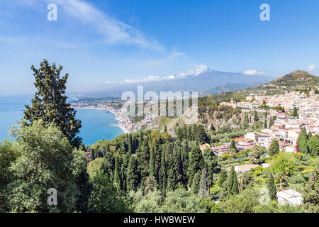 La città di Taormina a costa siciliana con il fumo Etna in lontananza Foto Stock