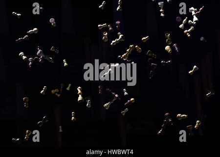 Fallling pezzi di scacchi, isolato di fronte a uno sfondo nero Foto Stock