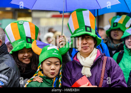 Belfast, Irlanda del Nord. 17 mar 2016 - i turisti cinesi usura verde, bianco e giallo cappelli per festeggiare San Patrizio. Foto Stock
