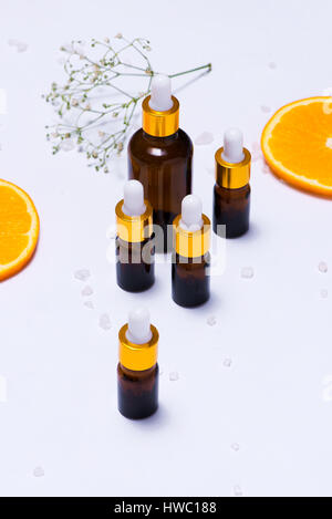 Il Branding mock-up. Olio essenziale naturale, bottiglia di cosmetici contenitori con fettine di arancia. Foto Stock