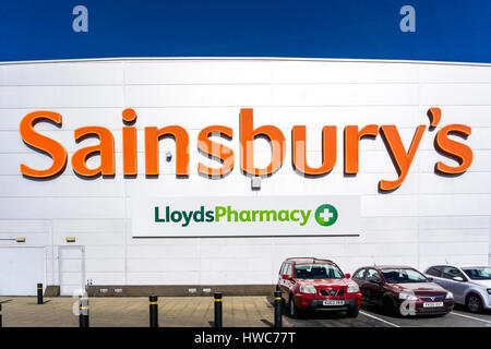 Un segno per Sainsbury's e Lloyds Pharmacy sul lato di un grande Sainsbury's supermarked a campana verde nel Sud di Londra. Foto Stock