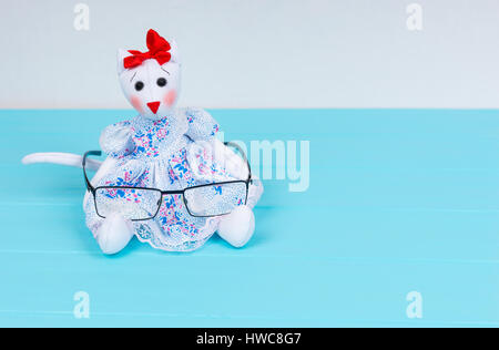 Giocattolo artigianale nella forma di un gatto in un abito elegante di contenimento dei bicchieri in legno scheda turchese Foto Stock