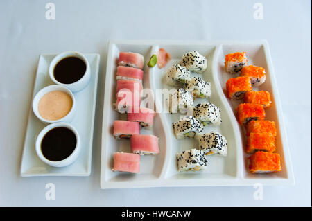 Sushi con salmone e caviale, zenzero rosa su piatto. Mensole e stuoia di  sushi di bambù. Giacitura piatta. Sfondo bianco Foto stock - Alamy