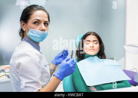 Dentista femmina pinze di trattenimento. Foto Stock