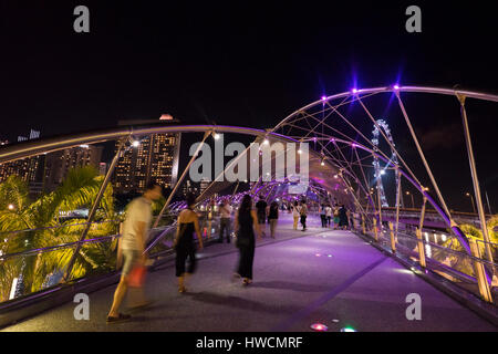 Vista orizzontale di persone attraversando a piedi il Ponte di elica in notturna a Singapore. Foto Stock