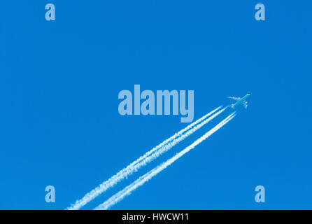 Un aereo con condensazione trail nel cielo blu, Ein Flugzeug mit Kondensstreifen am blauen Himmel Foto Stock