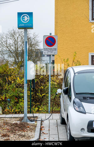 Auto elettrica in corrispondenza della stazione di carico, il simbolo per l'ecologia, la protezione del clima, innovazione, Elektroauto un Ladestation, simbolo für Ökologie, Klimaschutz, Inn Foto Stock