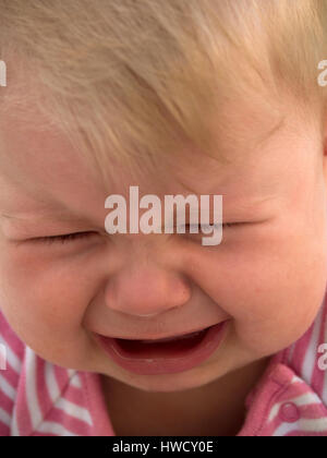 Gridando bambino giace su un prato ed è triste, Weinendes Baby liegt auf einer Wiese und traurig ist Foto Stock