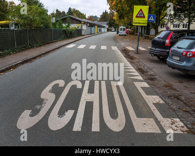 La parola scuola si trova sulla strada. La sicurezza di una scuola modo prima di una scuola, das Wort Schule steht auf der Strasse. Absicherung eines Schulweges vo Foto Stock