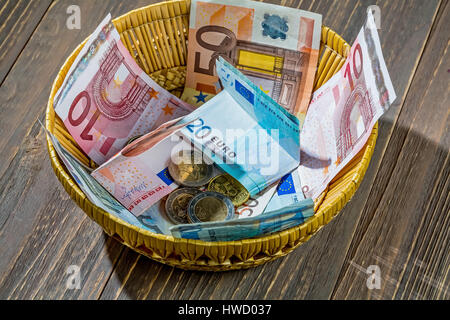 Un cestello con il denaro per le donazioni e suggerimenti, Ein Korb mit Geld für Spenden und Trinkgelder Foto Stock