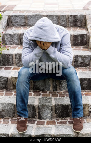 Un uomo si siede solitaria sui gradini, Ein Mann einsam sitzt auf Stufen Foto Stock