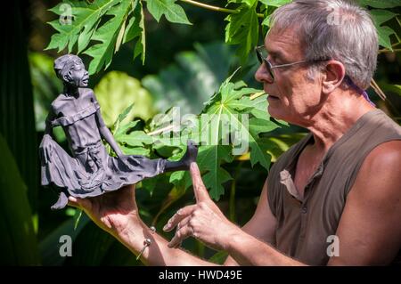 Seychelles, Isola di Mahe, Tom BOWERS con una delle sue sculture di giovane ragazza Seychellois nella sua bottega, Les Cannelles strada tra Anse Royale e Anse à la Mouche Foto Stock