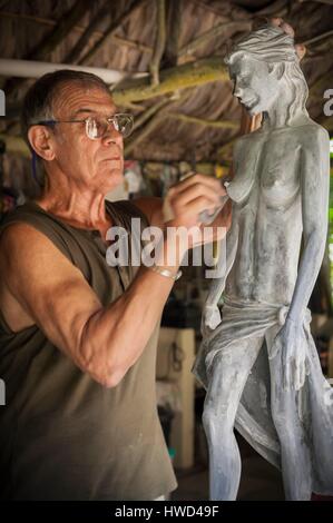 Seychelles, Isola di Mahe, Tom BOWERS carving una giovane ragazza Seychellois nella sua officina, su Les Cannelles strada tra Anse Royale e Anse à la Mouche Foto Stock