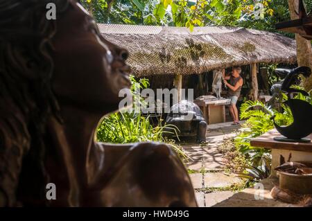 Seychelles, Isola di Mahe, Tom BOWERS carving una giovane ragazza Seychellois nella sua officina, su Les Cannelles strada tra Anse Royale e Anse à la Mouche Foto Stock