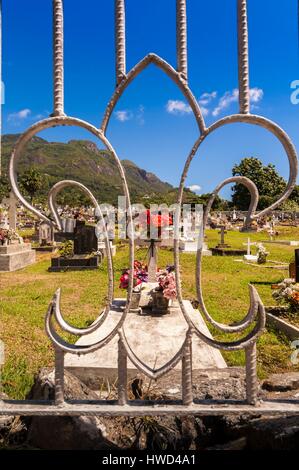 Seychelles, Isola di Mahe, il cimitero di Victoria attraverso un cancello con fiore di giglio, Morne Seychellois sfondo Foto Stock