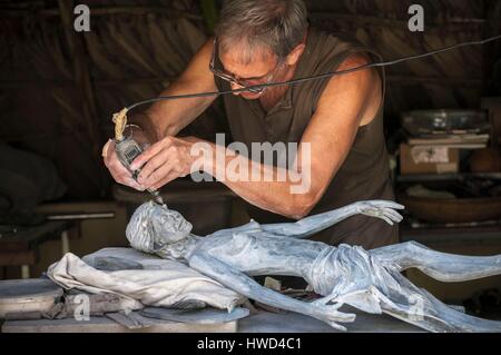 Seychelles, Isola di Mahe, Tom BOWERS carving una giovane ragazza Seychellois nella sua officina, su Les Cannelles strada tra Anse Royale e Anse à la Mouche Foto Stock