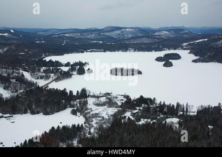 Canada, Québec provincia, regione Laurentians, boschi innevati e un lago ghiacciato (vista aerea) Foto Stock