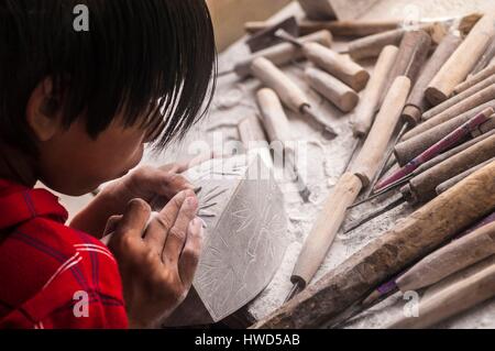 Il Vietnam, Alta Tonkin, provincia di Lao Cai, Sa Pa village, giovane artigiano scultore nella sua bottega Foto Stock
