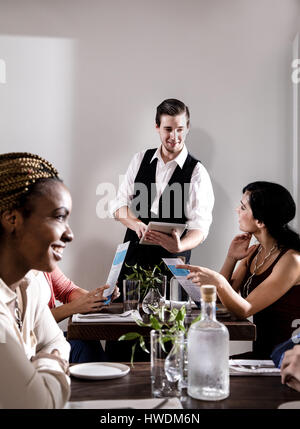 Cameriere che serve diners nel ristorante, cameriere con tavoletta digitale Foto Stock