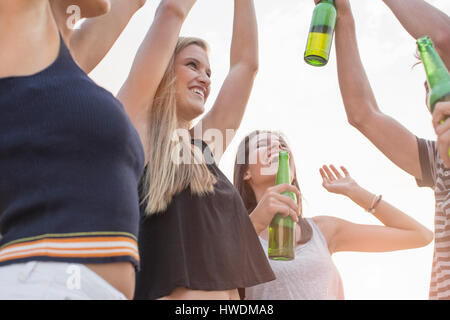Gruppo di amici di bere, godendo di festa in spiaggia Foto Stock
