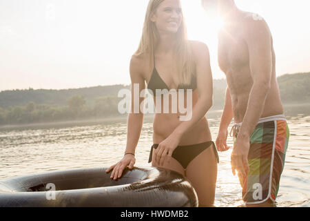 Giovane con anello gonfiabile in fiume Foto Stock