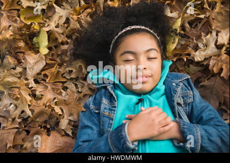 Vista aerea della ragazza distesa su foglie di autunno Foto Stock