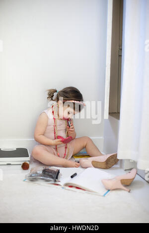 Ragazza vestire il, giocando con il rossetto Foto Stock