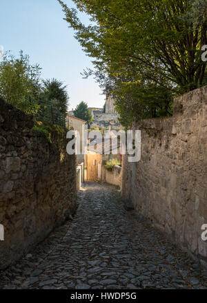 Una strada stretta con pareti di pietra di Saint Emilion, Francia Foto Stock