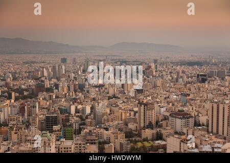 Iran, Teheran, elevati dello skyline della città dal tetto dell'Iran Park, crepuscolo Foto Stock