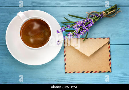 Vuoto notebook bianco,busta, mazzetto di lavanda e tazza di caffè sulla scrivania Foto Stock