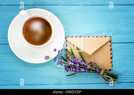 Vuoto notebook bianco,busta, mazzetto di lavanda e tazza di caffè sulla scrivania Foto Stock